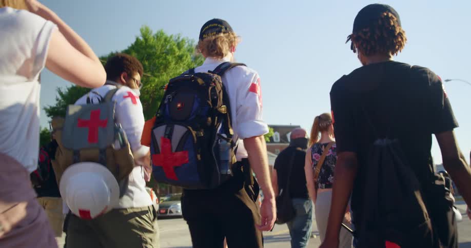 A group are marching down the street on a sunny day