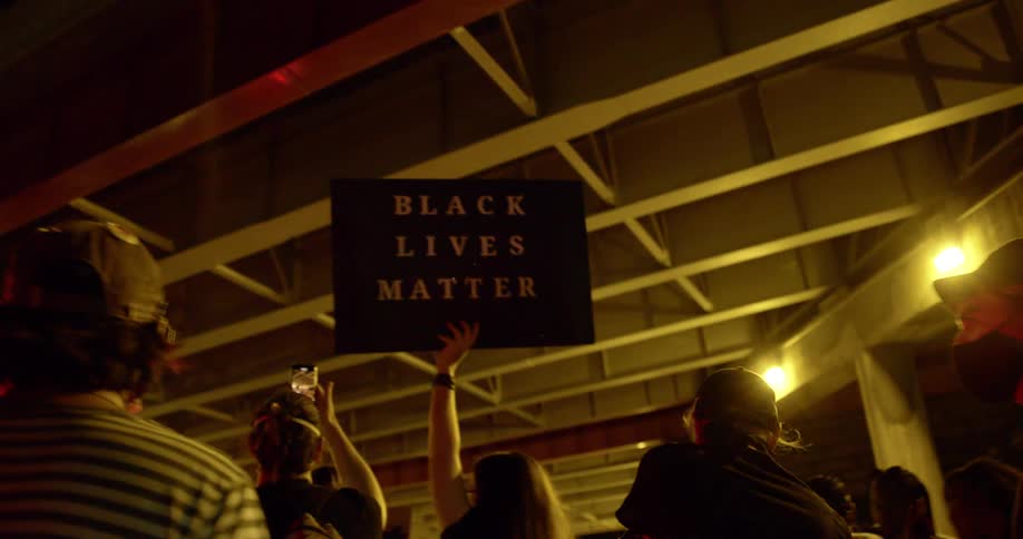 People hold up signs and take pictures at a protest