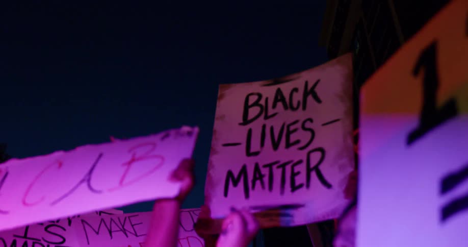 People hold up signs at a protest