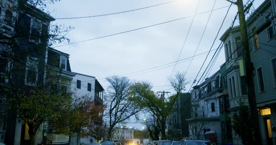 A car drives up past the homes