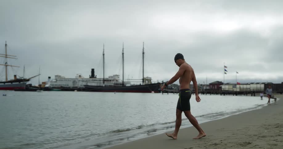 A man walking on the beach into the water