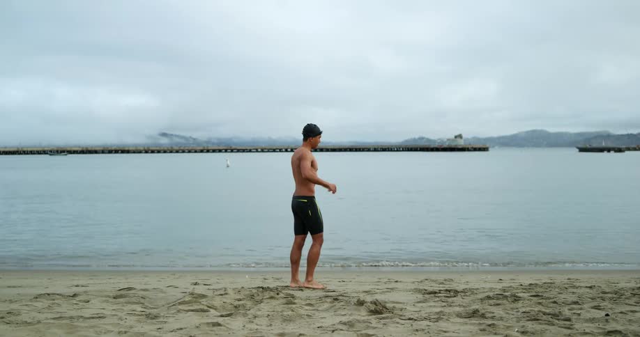 A man is stretching at the beach