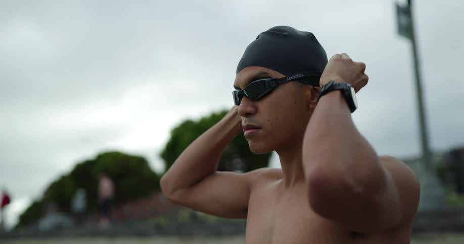 Swimmer dons goggles as others walk around in background