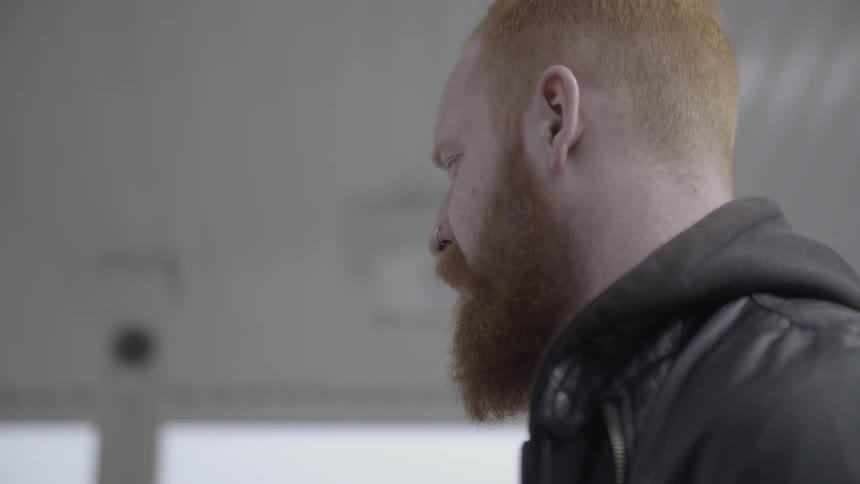 A man is standing outside and turns his head