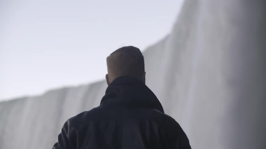 A man watches a large waterfall