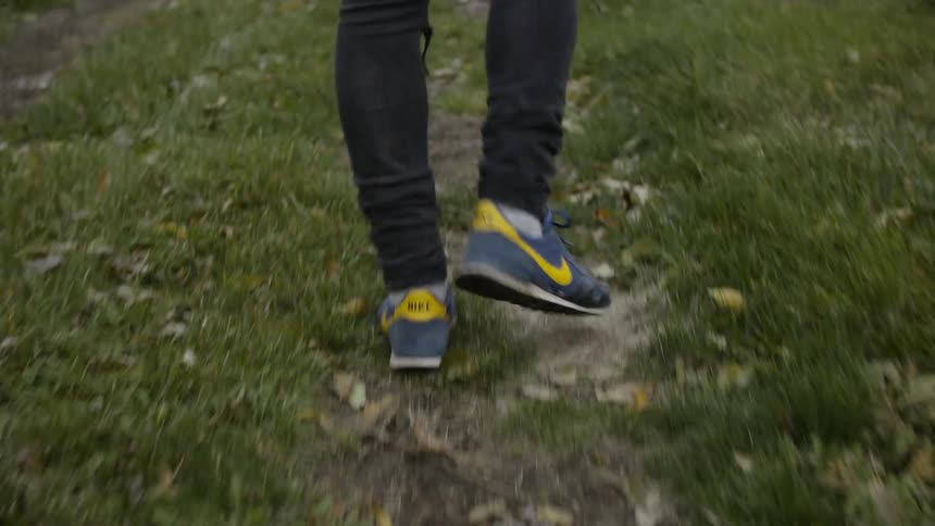 Close up of feet walking alone some green grass