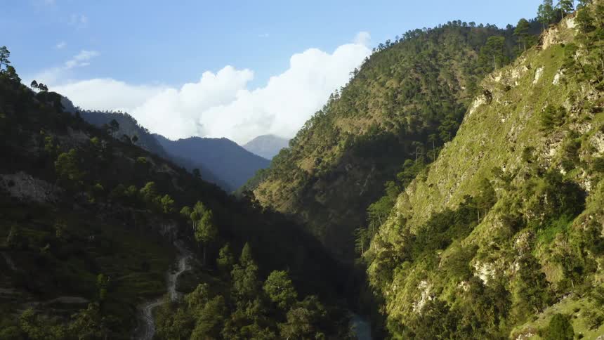An aerial view of a valley and tree covered hills