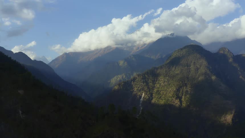 Aerial view of high mountains with a valley on a partly cloudy day