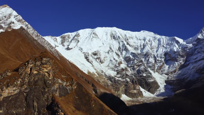 An aerial view of snow covered mountains is displayed