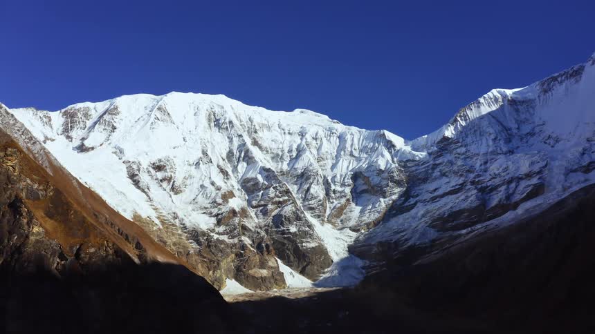 A snow and ice covered mountain range with the sky in the background