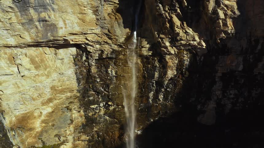 A waterfall on a sheer stone cliff during the day