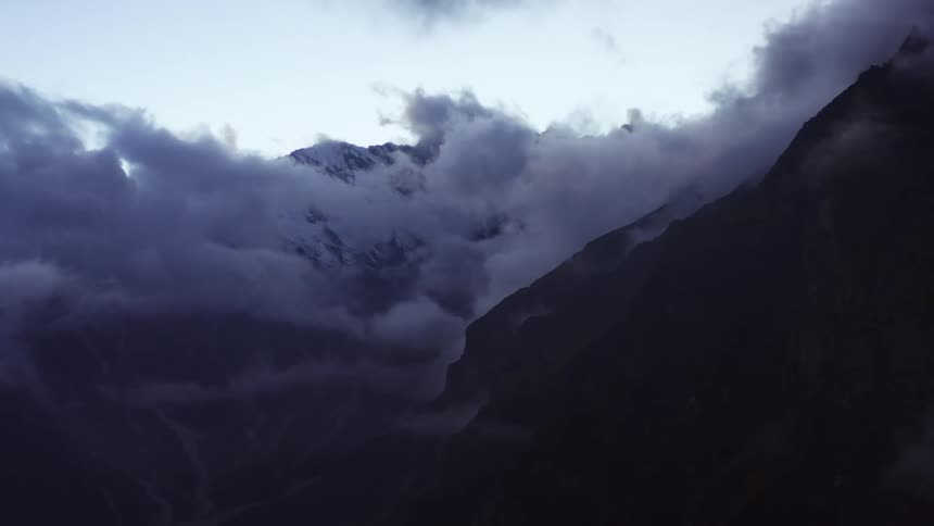 Dense and fluffy clouds obscure the peaks of a mountain range
