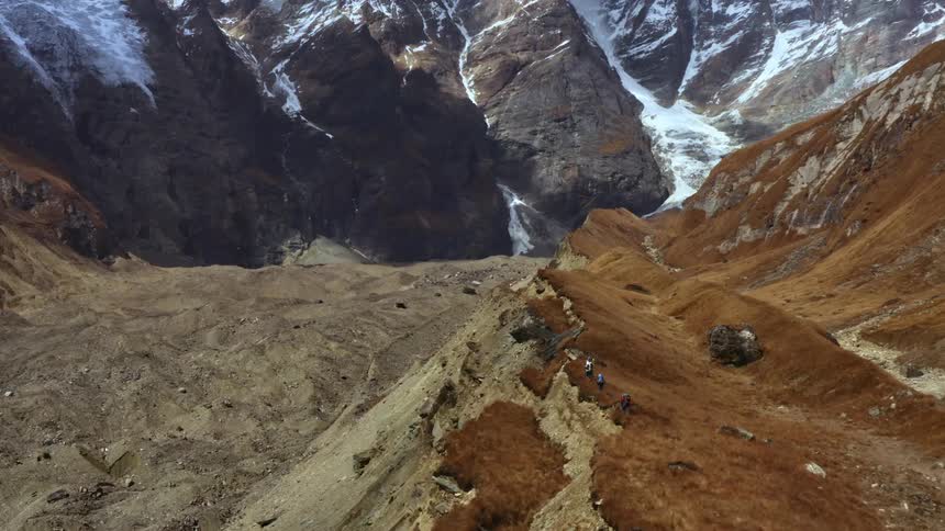 Hikers walk in a single file line along the peak of a mountain