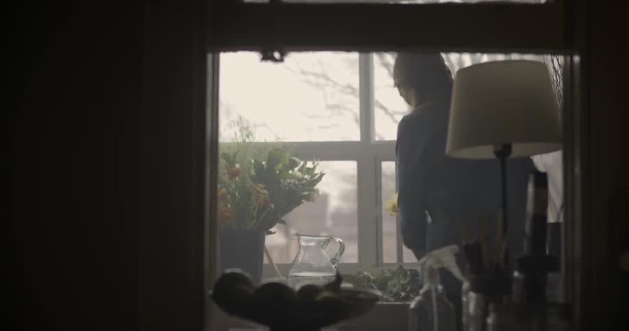 A woman walks over to a table with flowers