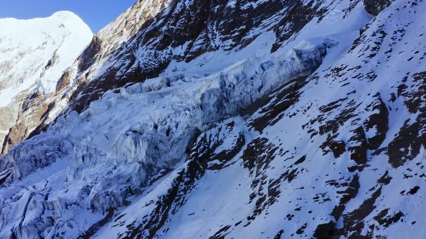 Aerial view of snow covered mountains is displayed