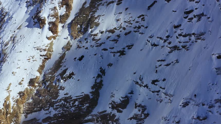 Hikers hiking on a snow covered mountain