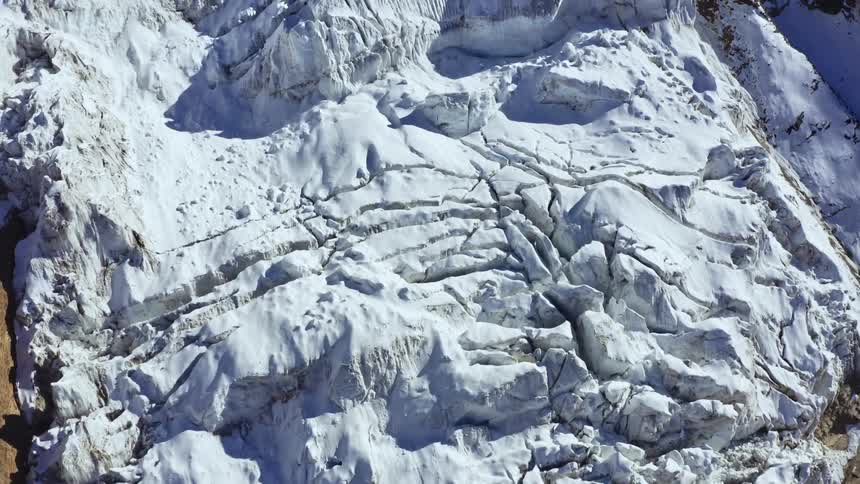 An aerial view of snow covered mountains is displayed