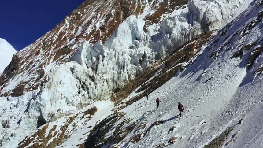 Three hikers hiking on a snowy mountain