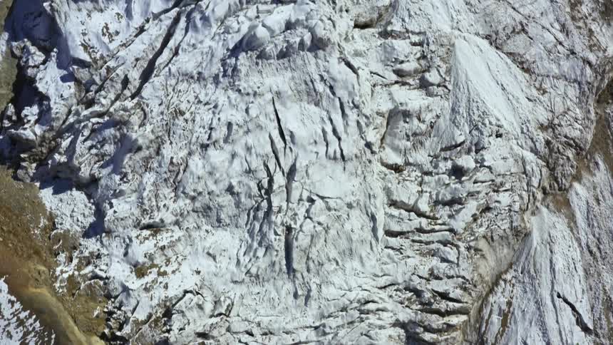 A mountain range with snow and ice light and shadow