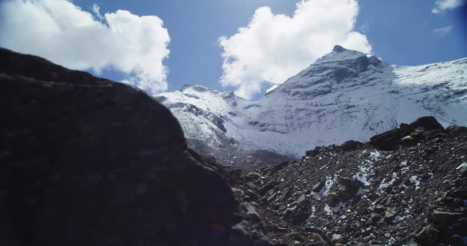 View of snow capped mountains with a mountain slope against the blue sky
