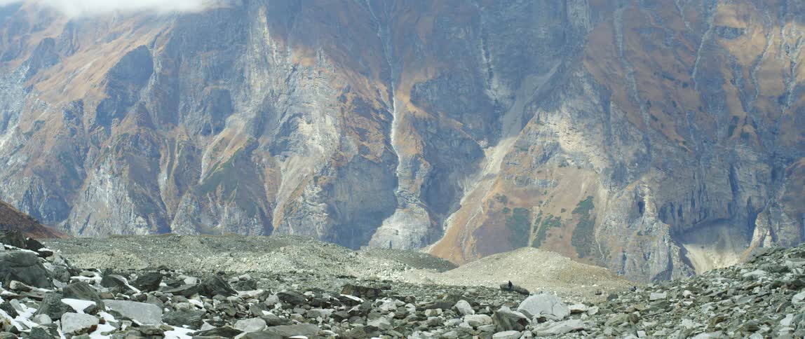 A landscape covered in stones at the base of a mountain on a sunny day
