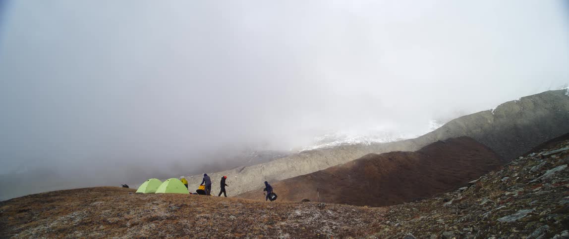 A group of people setting up tents on a mountain