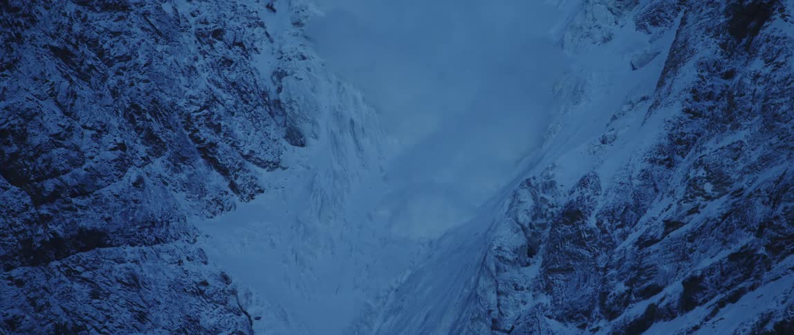 Avalanche cascading down mountainside at dusk