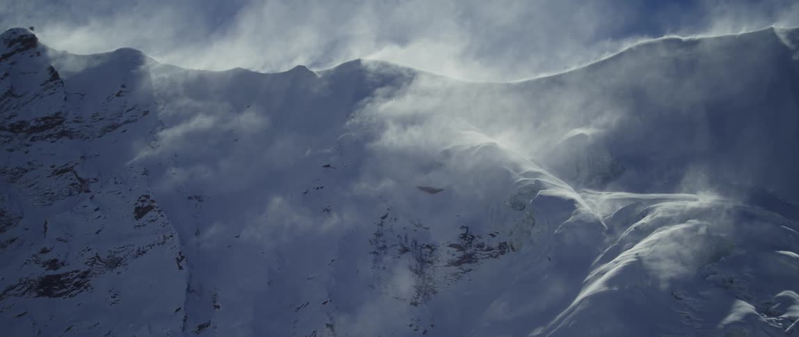 Aerial view of snow covered mountains is displayed