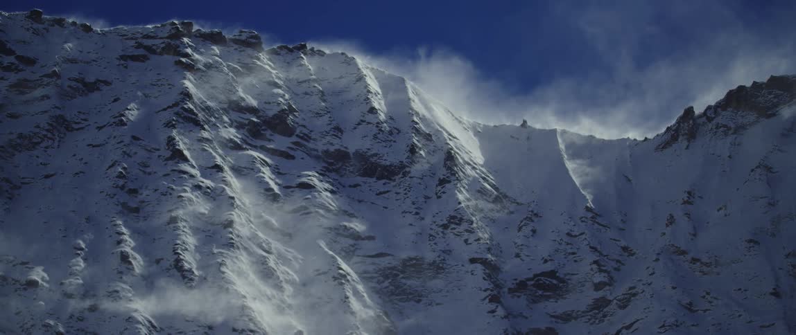 Aerial view of snow covered mountains is displayed
