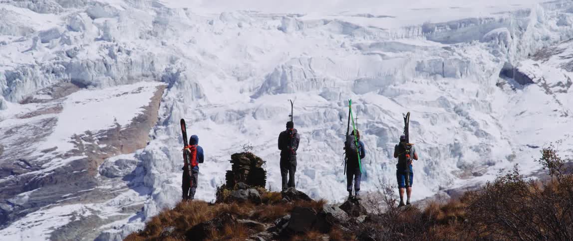 Four skiers standing on a snowy mountainside