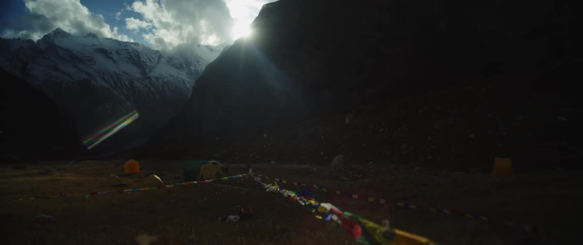 Tents and flags at a basecamp on a mountain