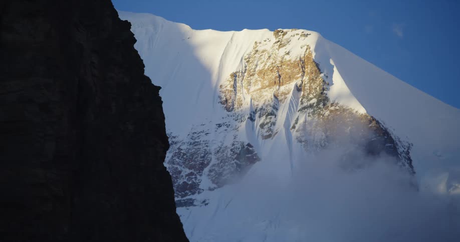 Snow covered mountainside and steep cliff