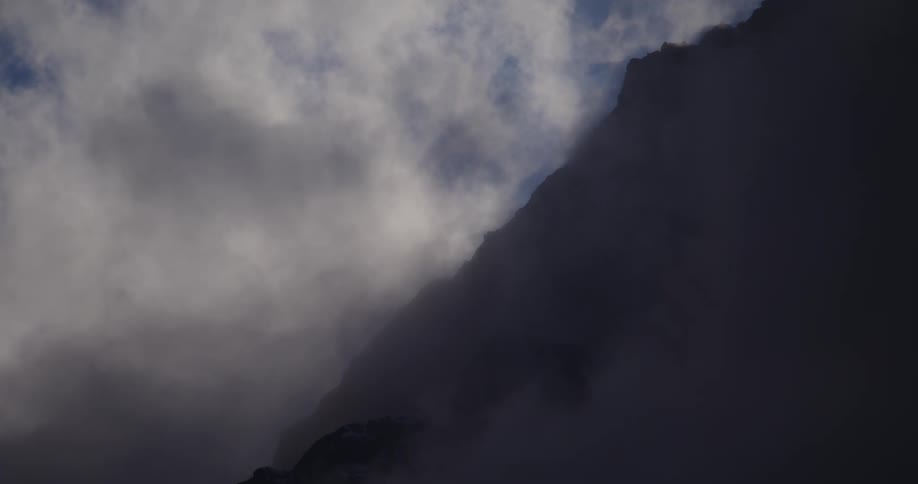 A mountain slope with clouds and fog