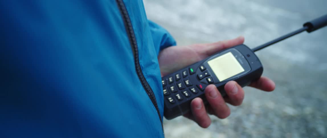 A man standing outside uses a walkie talkie