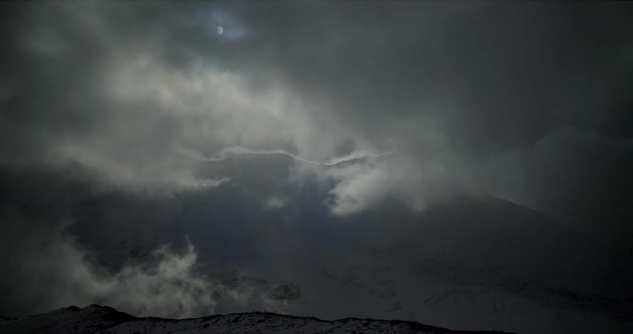 Aerial view of clouds covering the mountains is displayed at night