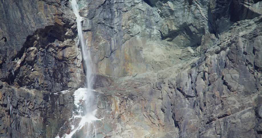 Tall waterfall on rocky mountainside