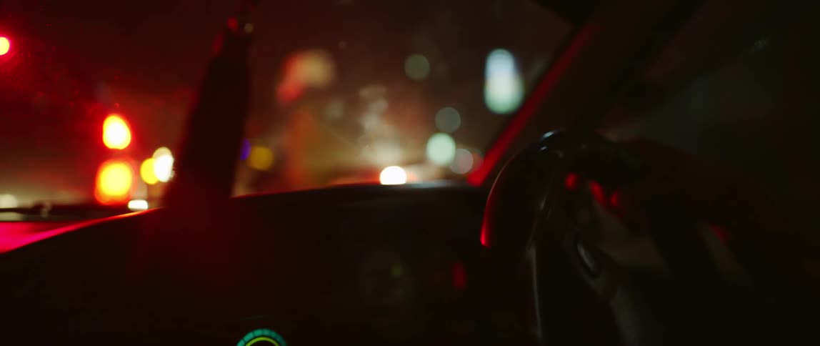 A school graduation tassel hangs from the rearview mirror of a vehicle that pulls up behind a motorcycle in heavy traffic