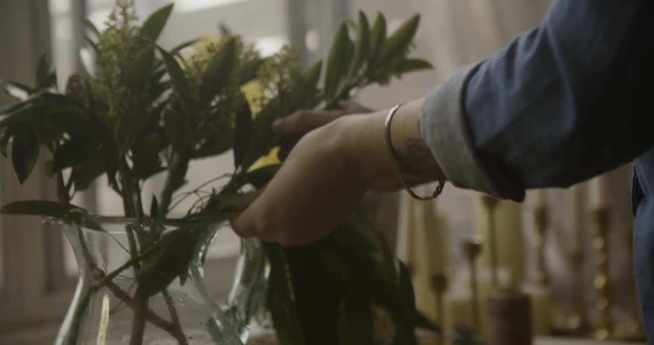 A woman putting together a floral arrangement