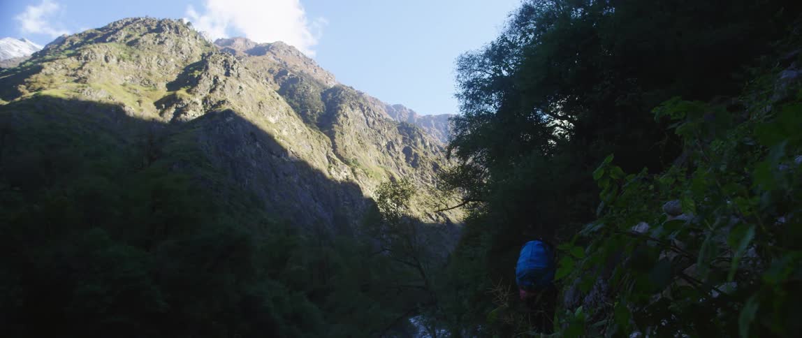 A person hiking down a mountain towards a river