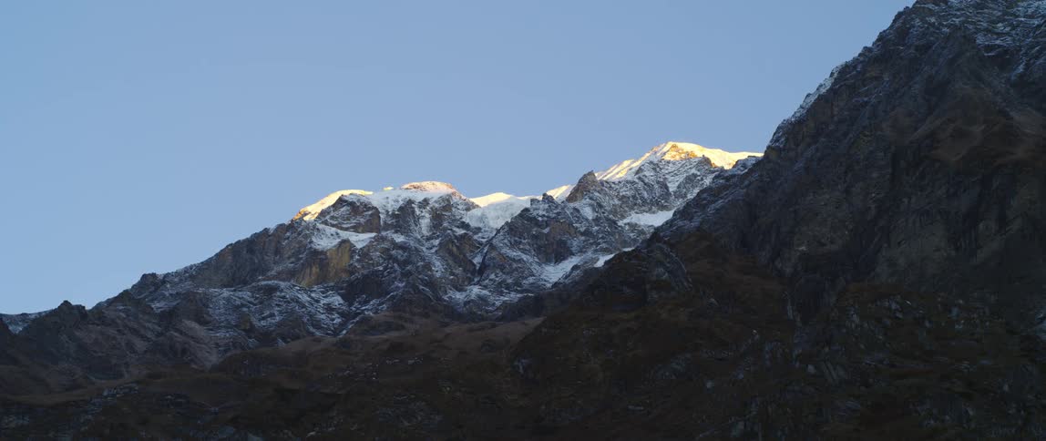 Snow is covering the mountains in the daytime