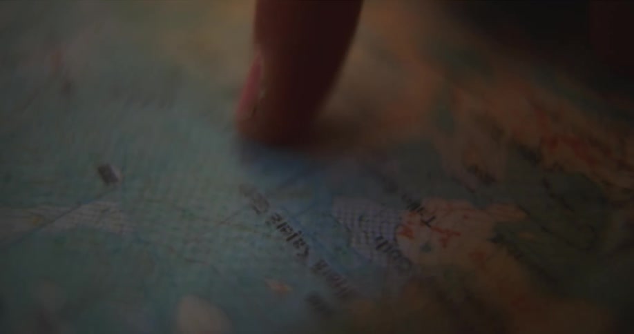 A person runs their finger along a printed map