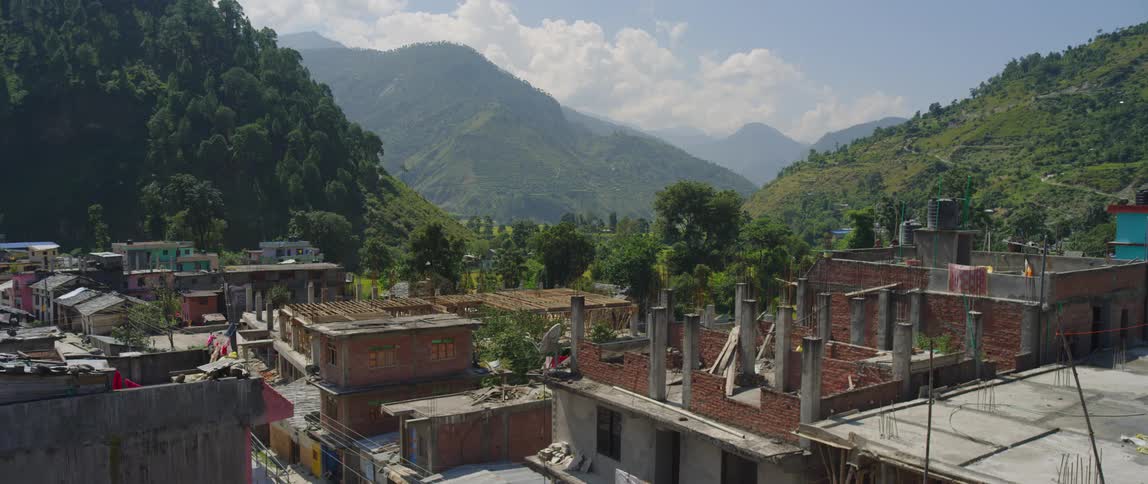 Homes sit close together below a mountain in a third world city
