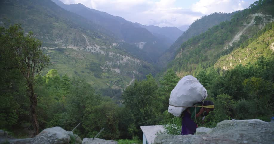 A person carrying a full large back pack up a mountain