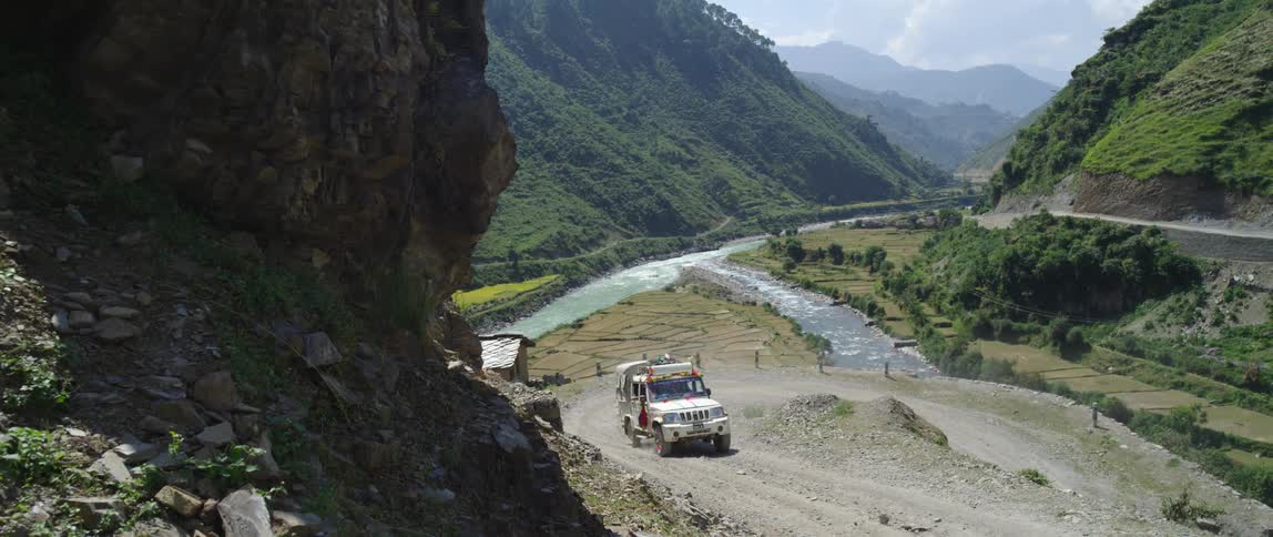 A truck drives up the dirt trail