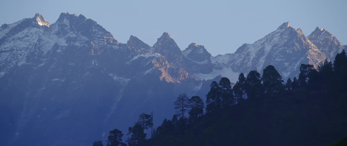 Snow capped mountain ranges against the cloudless sky at dawn