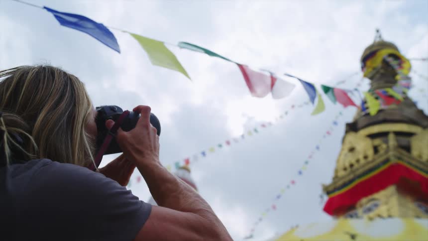 A woman takes a picture of a temple