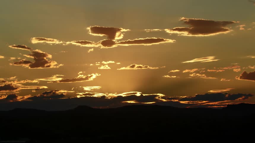 Clouds are silhouetted against the sunset