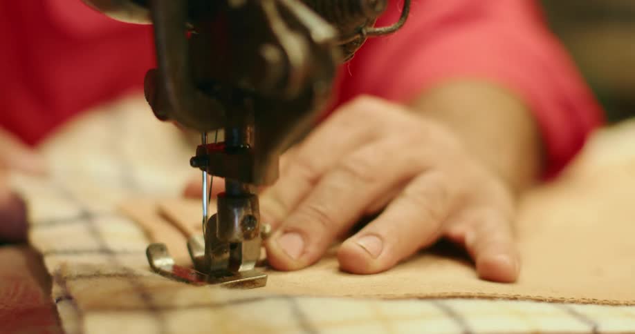 A person uses a sewing machine to sew two fabrics together