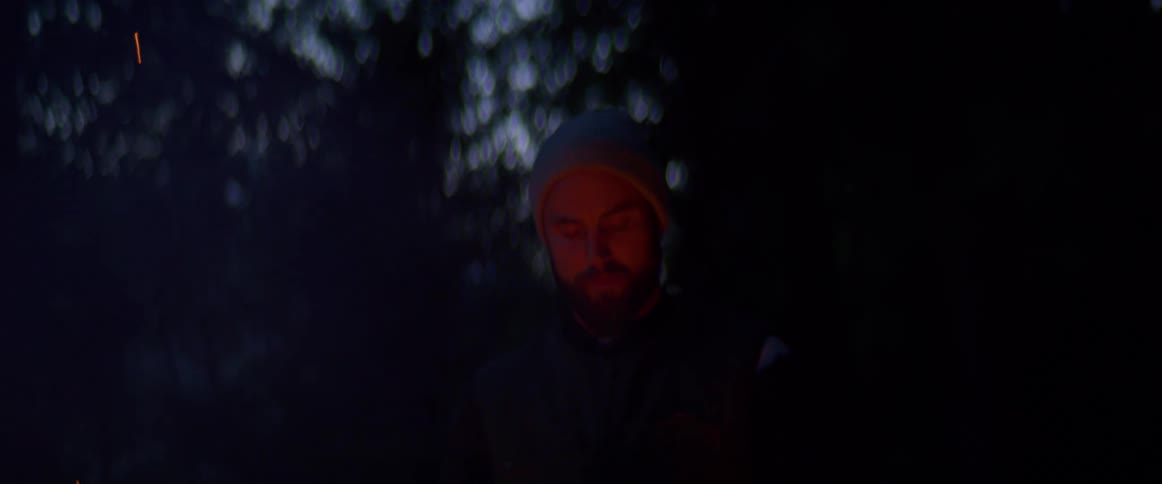 A man warming his hands by camp fire