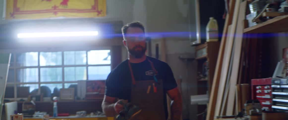 A man grabbing tools in a shop